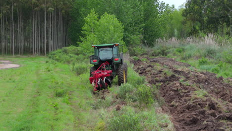 a harvester machine in a forest field preparing to dig up the ground for harvesting.