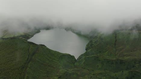 vista aérea del lago funda con nubes bajas en la isla de flores, azores - toma de avión no tripulado
