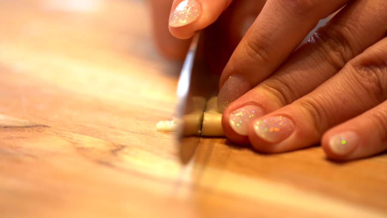 Garlic being chopped on a wooden board 4K