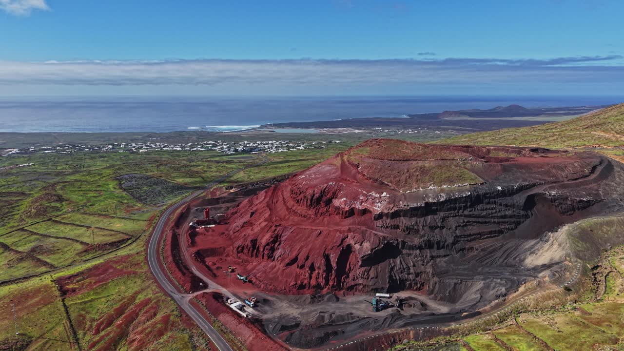 Vulkanlandskap med röd jord nära kusten på Lanzarote, Spanien.