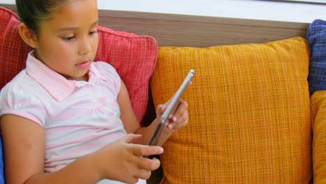 Schoolgirl-using-digital-tablet-in-the-library-at-school-4k