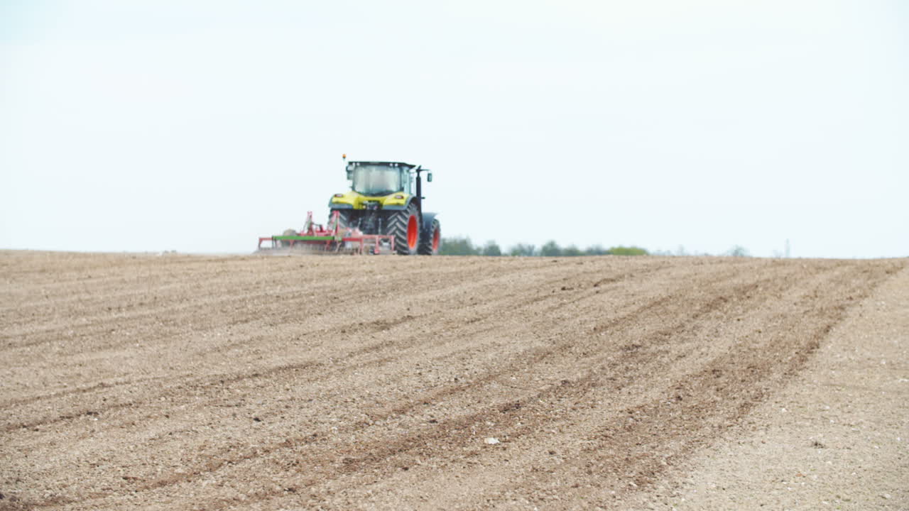 campo de arado del tractor con gradas (brote ancho)