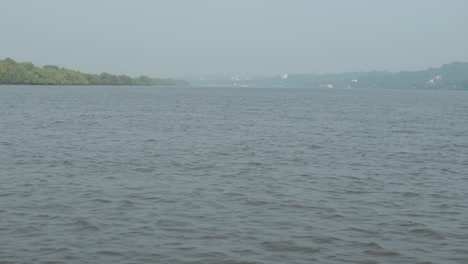 Tranquil-scene-of-blue-river-water-from-the-perspective-of-a-boat-in-India