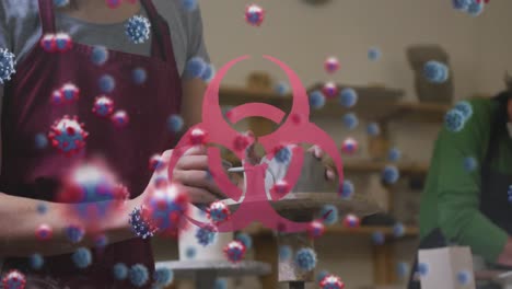 animación de células de virus y peligro biológico sobre las manos de una mujer caucásica en un taller de arcilla