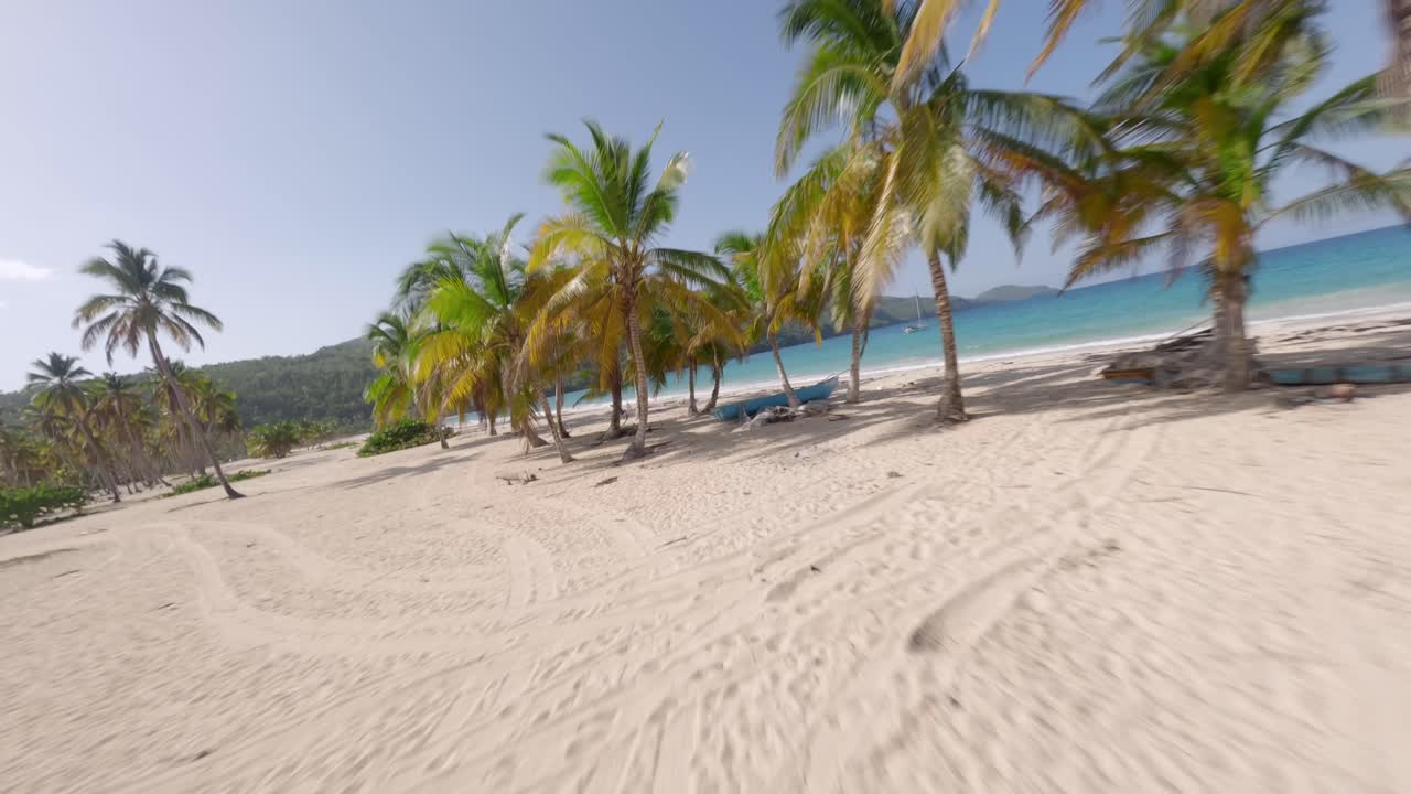 avión no tripulado volando a baja altitud sobre la playa blanca de playa rincon y sobre el mar turquesa, las galeras en la república dominicana