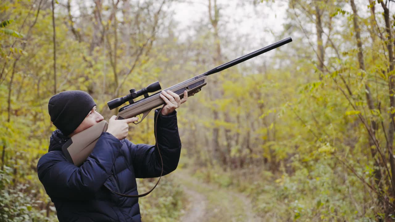 Hunter aiming for wildlife. Close up of hunter aiming down his rifle in autumn season