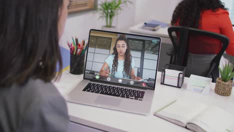 Biracial-businesswoman-using-laptop-for-video-call-with-biracial-business-colleague