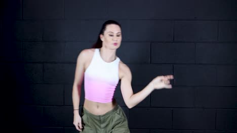 female professional dancer performing mannequin dancing machine in black background, sexy modern young girl dancing in studio