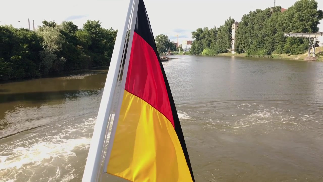 Bandiera tricolore della Germania su una barca che naviga attraverso le paludi, inquadratura media.