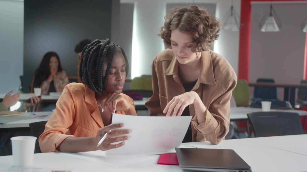 la joven maestra africana está explicando a su estudiante cómo hacer la tarea que le dio, en cámara lenta