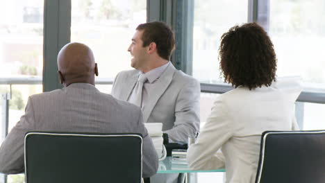 three smart businesspeople laughing in a meeting