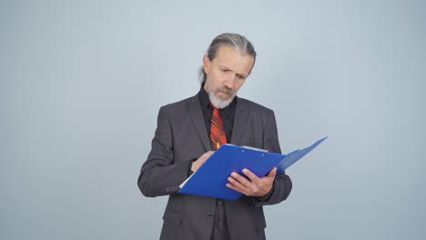 el hombre de negocios examina el papeleo y se enoja.