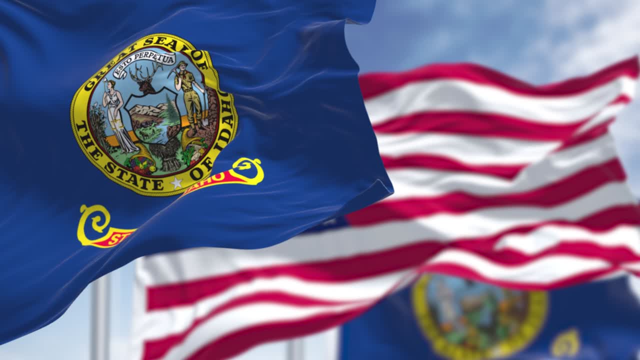 The Idaho Seamless loop in slow motion with two Idaho state flags waving along with the national flag of the United States of America flag waving along with the national flag of the United States of America
