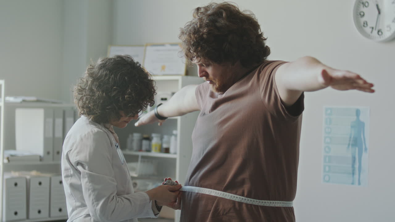 Doctor measuring patient's waist circumference