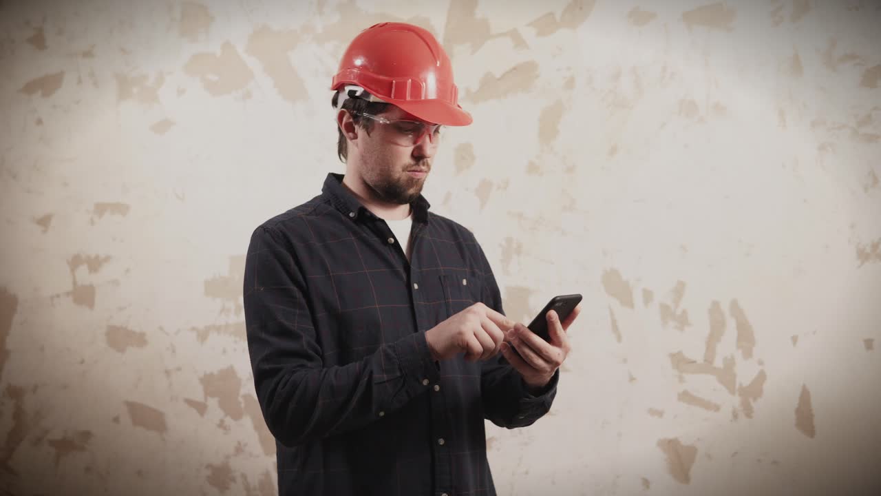 trabajador de la construcción que usa un teléfono inteligente