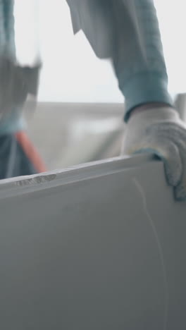 skilled man in special gloves holds large rubber hammer and aligns grey gypsum plasterboard constructions close view