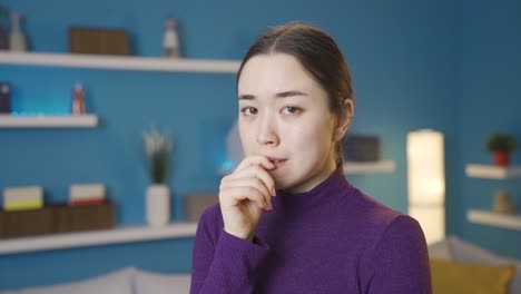 asian woman looking at camera nervously.