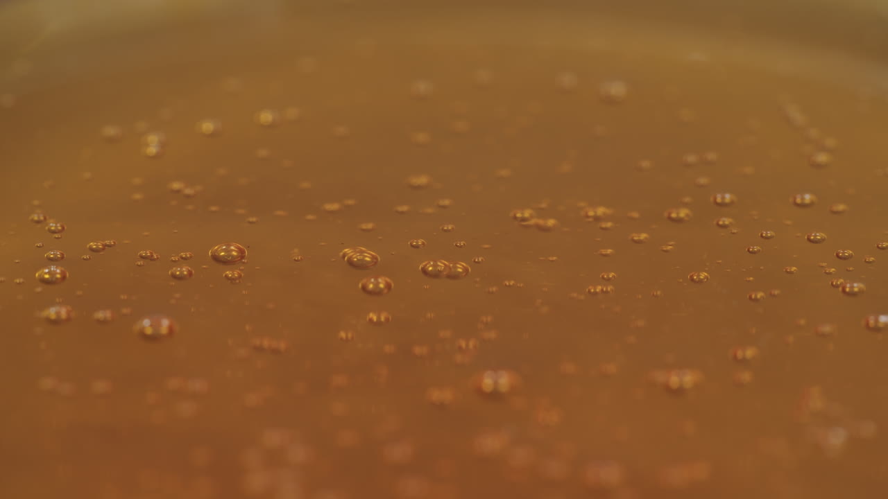 primer plano en bucle de miel goteando sobre una superficie llena de más miel