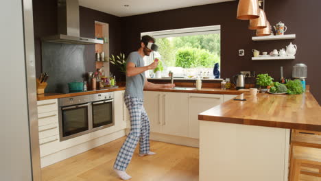 man in vr headset dancing and gaming in a kitchen