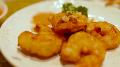 golden fried shrimp on a white plate with garnish, captured in warm lighting at a gold coast restaurant
