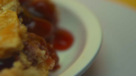 [cámara utilizada: canon c300] toma macro: una rebanada de pastel de cerezas giratoria, con corteza dorada y cerezas sueltas
