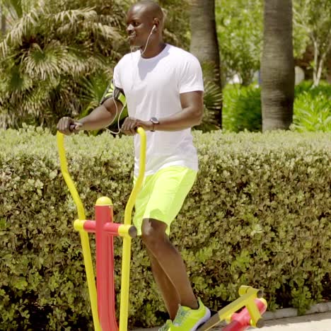 man in park uses painted metal exercise equipment