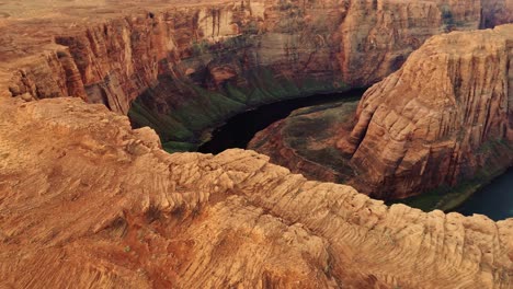 majestic sandstone cliffs curve around emerald colorado river in dramatic flight