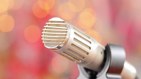 Microphone-on-stage-against-a-blurry-light-,blurry-background.