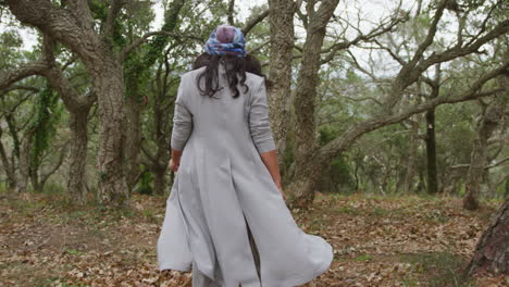 beautiful young woman walking through the autumn forest