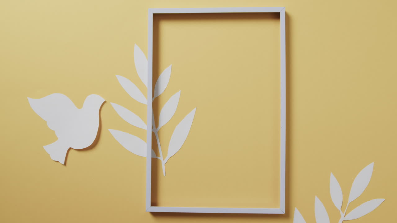 primer plano de paloma blanca con marco y hojas y copia de espacio en fondo amarillo