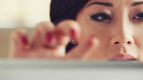 mujer asiática usando una tableta con pantalla táctil ipad