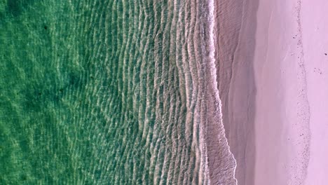 a peaceful beach with waves crashing on the sand and a green ocean wave coming in from the shore and a green ocean wave coming in from the top