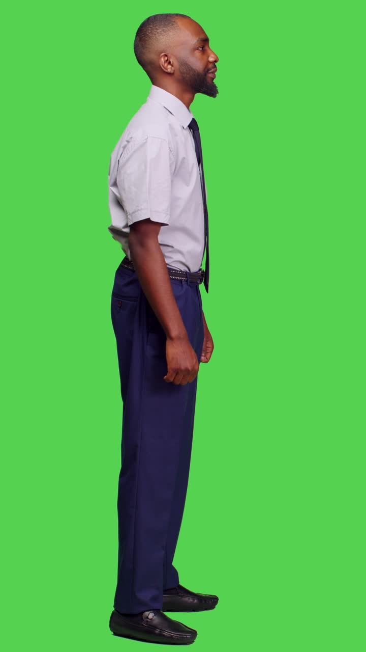 Vertical video: Side view of entrepreneur posing on camera over full body green screen