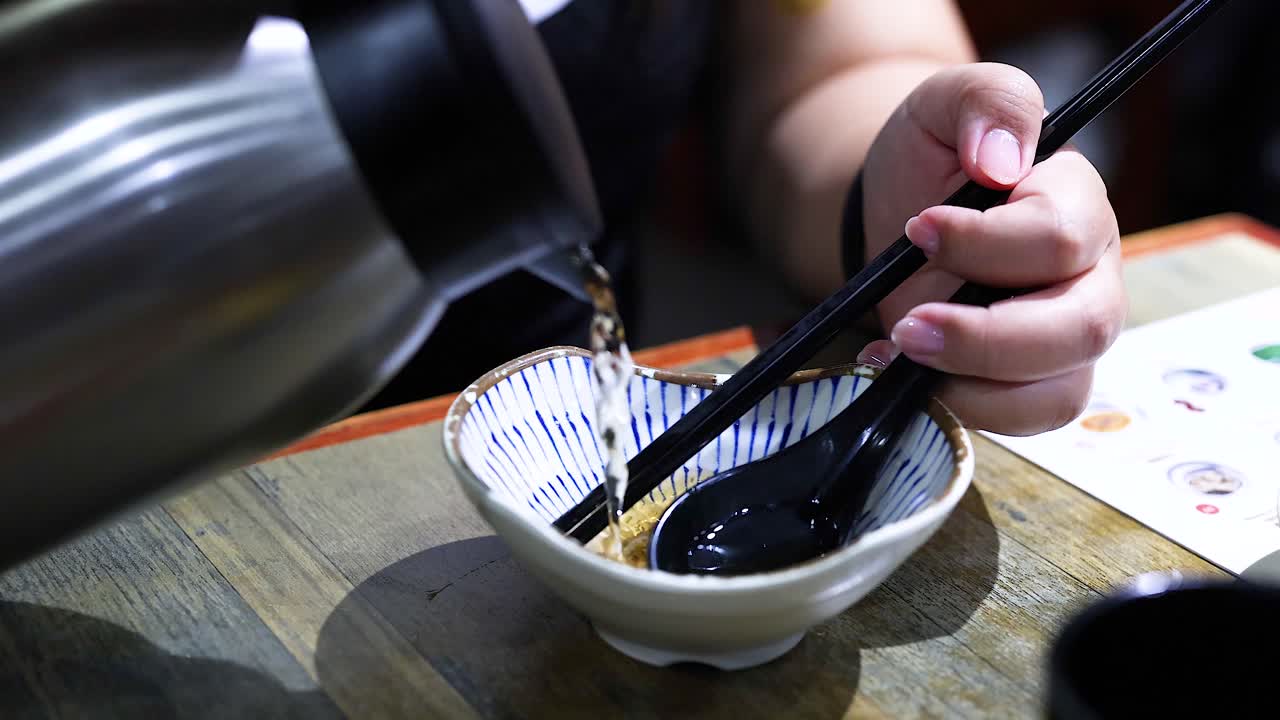 persona vierte agua en un cuenco pequeño