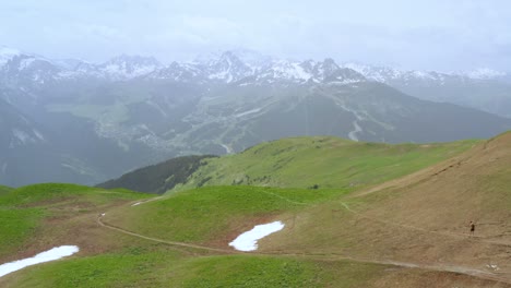 antena: alpes europeos, telón de fondo de montañas nevadas con excursionistas en primer plano