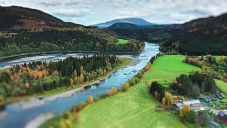 the aerial view of the scenic river cutting through farm fields and forests, framed by early autumn foliage