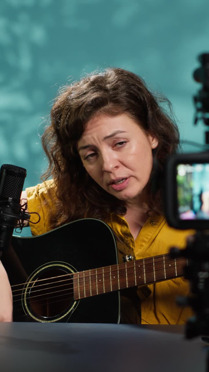 Donna che suona la chitarra acustica e canta per un video online