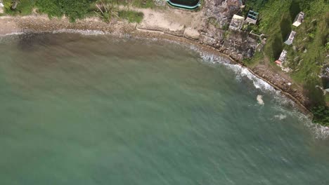 Aerial-trucking-shot-flying-over-the-ocean-and-approaches-a-abandoned-and-derelict-beach-bungalow-tourist-resort-in-Koh-Chang-Thailand-due-to-the-effect-of-covid-on-global-travel-and-tourism