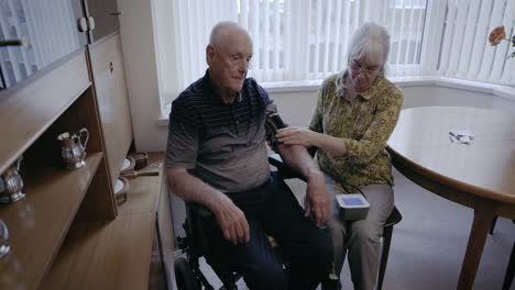 senior man having his blood pressure checked by a caregiver