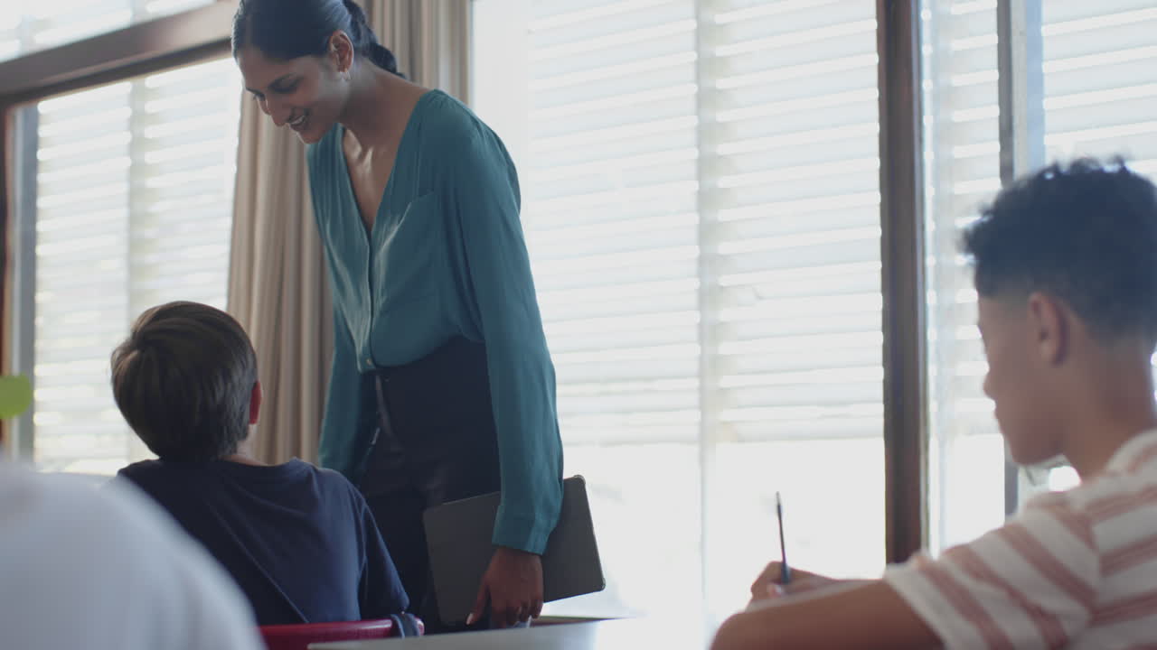 In school, teacher smiling and interacting with students in classroom setting