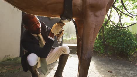 hombre afroamericano instalando la silla de caballo