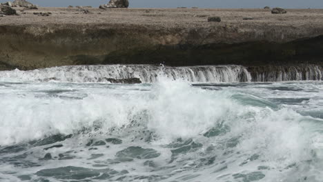 Olas-Rompiendo-En-Las-Rocas,-Creando-Cascadas,-Bonaire