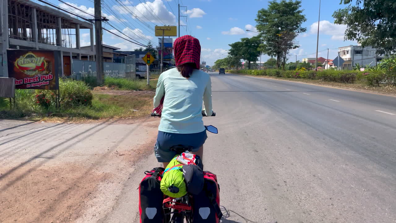 뒷좌석에 패니어와 식료품을 싣고 자전거를 타고 출퇴근하는 여성의 다이내믹한 영상