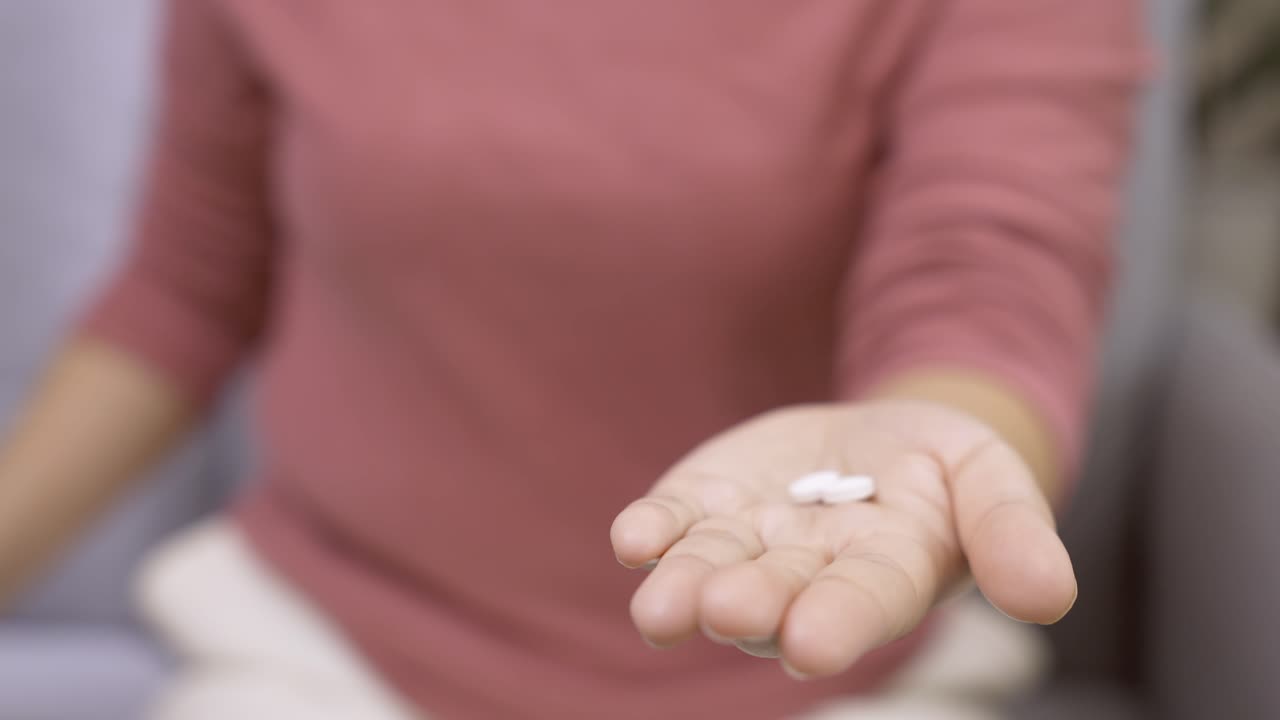 mujer joven con pastillas de vitaminas en la palma para usar y fortalecer la inmunidad