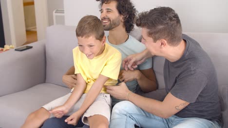 padres gay alegres y un niño divirtiéndose en casa
