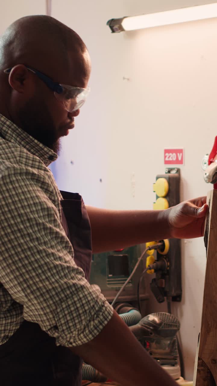 African American Carpenter Inspecting Wood in Workshop