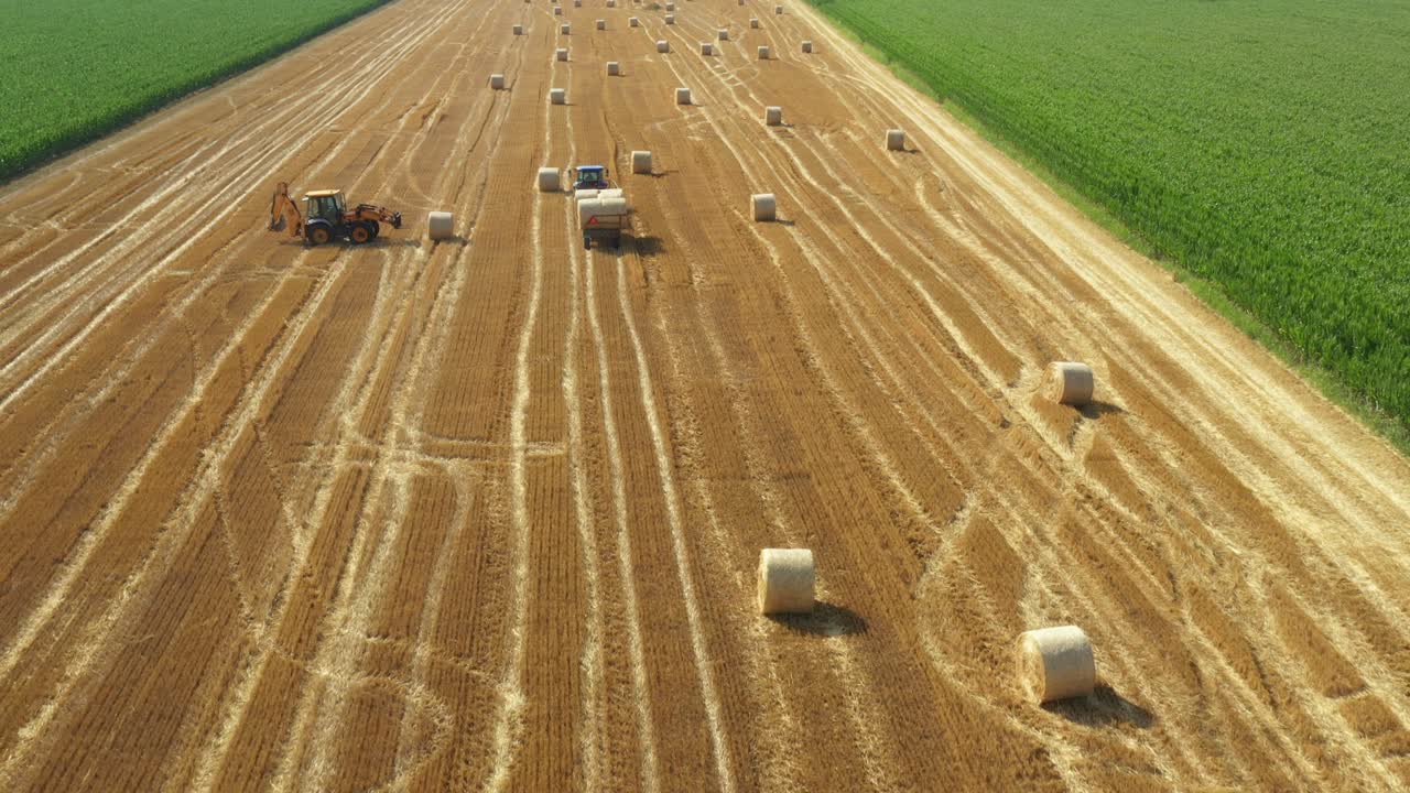 Above view of agricultural field, collecting round bales of straw
