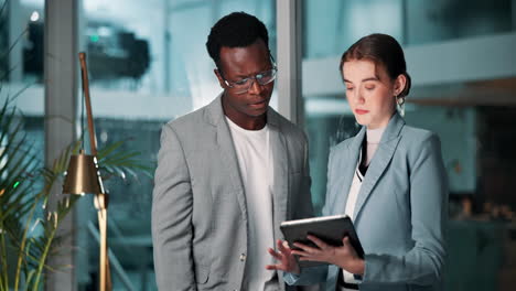 two business professionals discussing work on a tablet