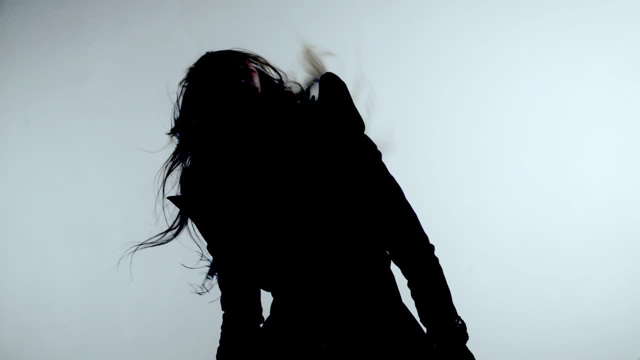 silueta de mujer bailando sobre un fondo gris. mujer hermosa dando vueltas