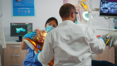 Senior-woman-sitting-on-dentist-chair-at-dental-clinic